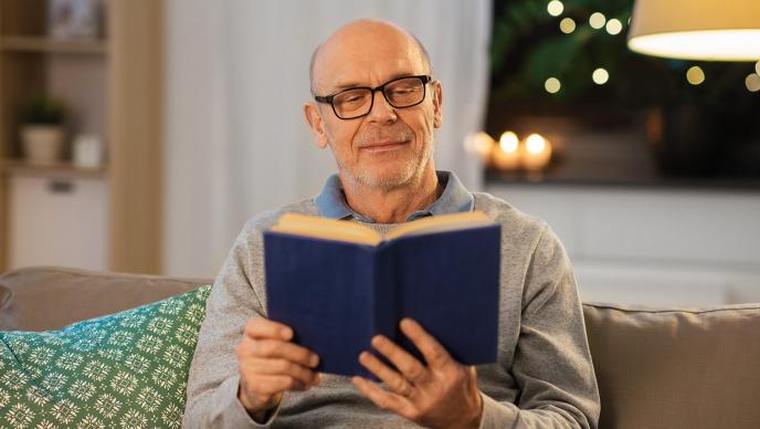 personne lisant un livre dans une pièce bien éclairée