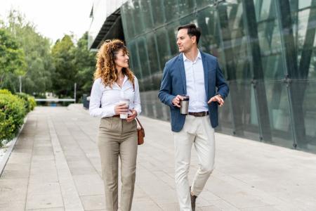 Photo d'une femme et d'un homme en tenue professionnelle, marchant